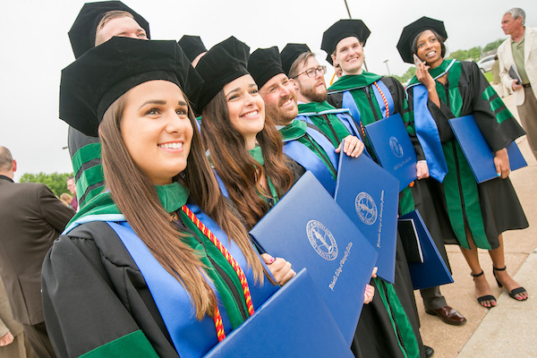 Graduates showing their diplomas